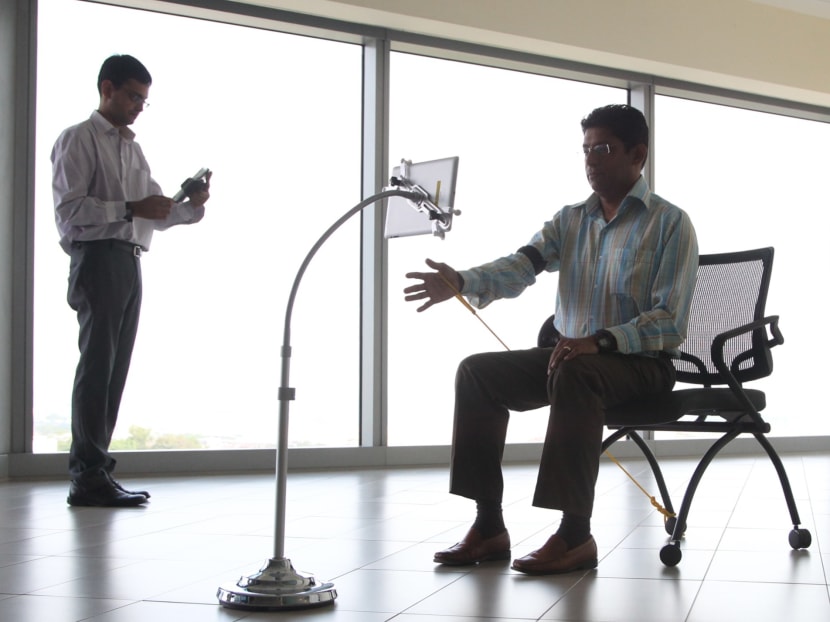 A demonstration showing a recovering "patient" using an iPad installed with a proprietary app to enable rehabilitation exercises to be carried out away from the hospital. Footage of the "patient's" workout is then viewed and corrected by a therapist from a hospital, March 31, 2014. Photo: Don Wong