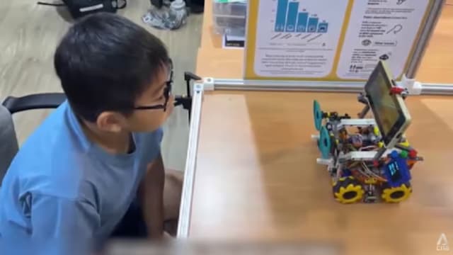 本地两名小学生设计机器人 控制孩童和屏幕距离