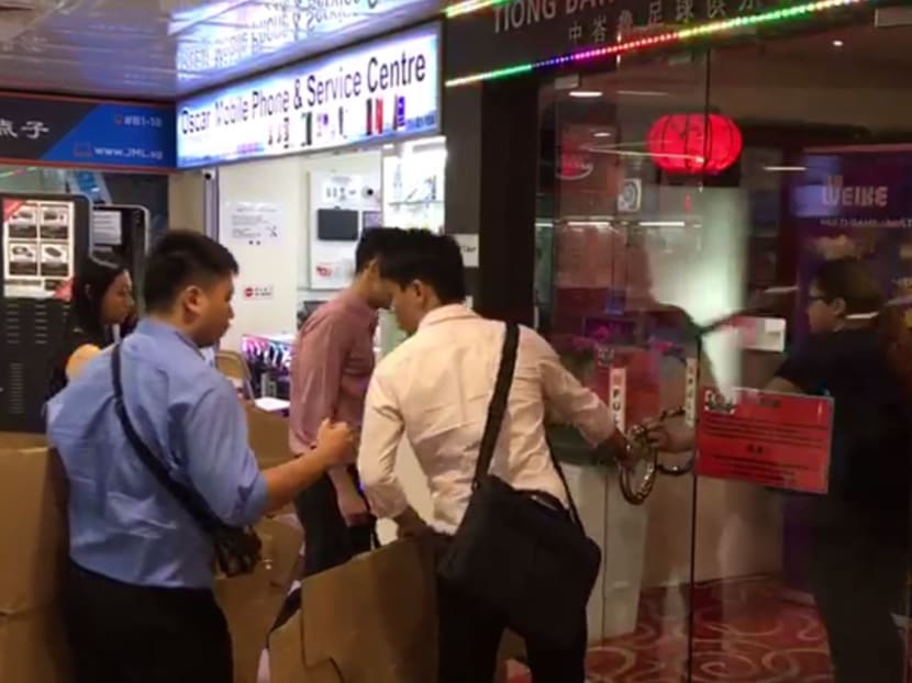 A still from a video showing investigators carrying cardboard boxes into the Tiong Bahru FC clubhouse. A still from a video showing investigators carrying cardboard boxes into the Tiong Bahru FC clubhouse.