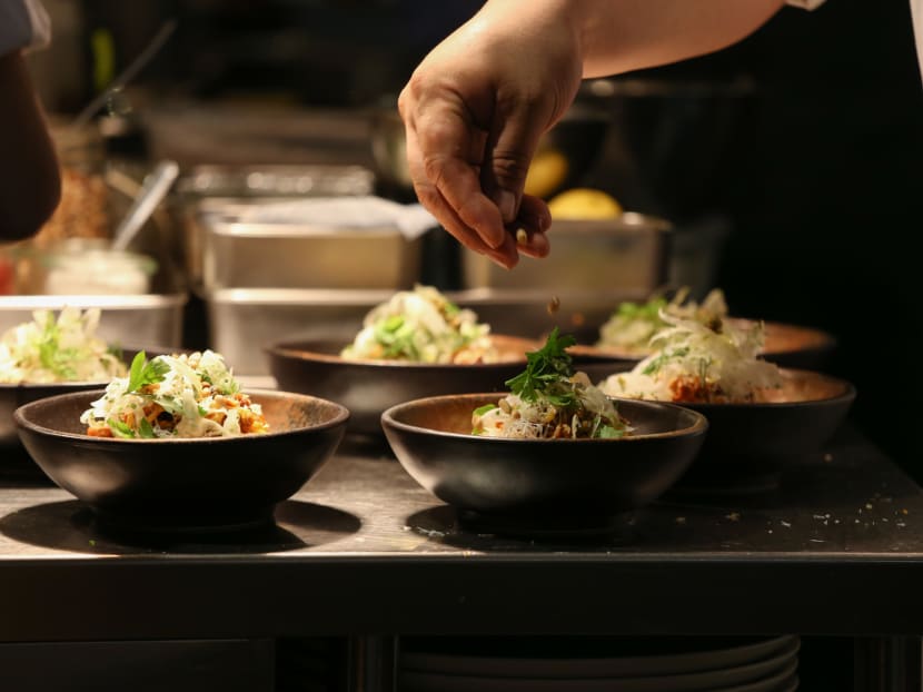 A close-up of chef Victor Loy preparing dishes during The Food Bank Singapore and Plentyfull food-tasting event for the One-Dish@A-Time initiative, which aims to encourage consumers to have lunch made from ugly and donated food to raise money to feed the needy.