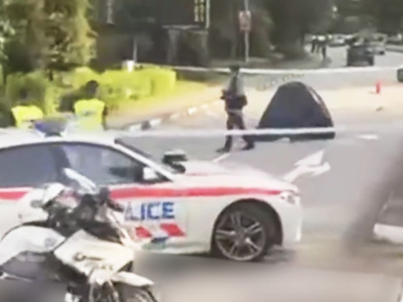 A screenshot from a video clip showing a blue tent and several police vehicles at the accident scene.