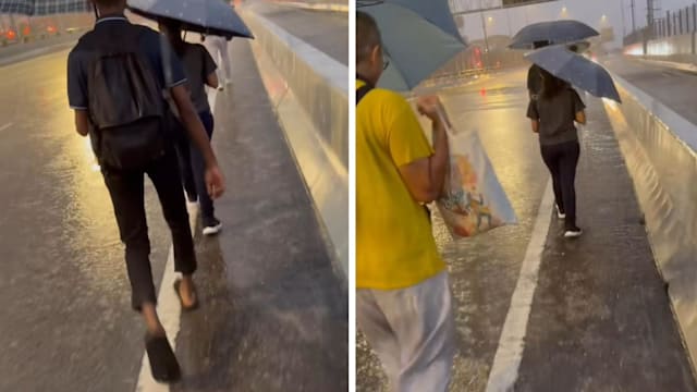 风雨中撑伞前行 越堤族上班路惹人心疼