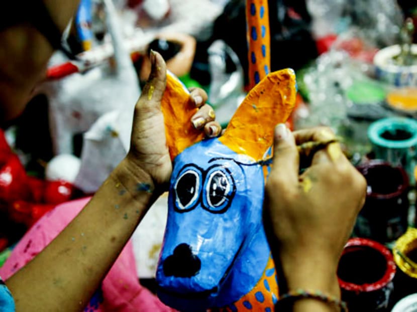 A craftswomen sets a papier-mâché turtle out to dry. Photo: Myanmar Times