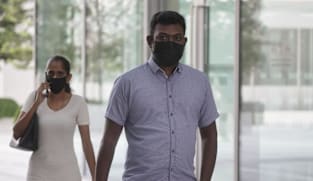 Woman who made construction workers hold up placards demanding payment fined, along with husband