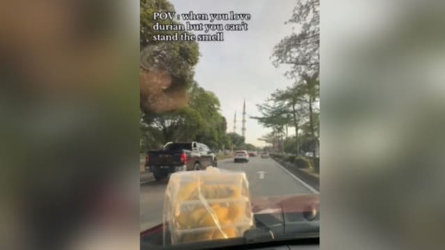 不想车内残留味道 马国女把榴梿放车盖载着走