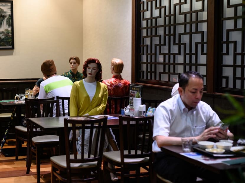 Diners eat alongside mannequins, used as a method to maintain social distancing among diners, at a restaurant in the Akabane district of Tokyo on July 26, 2020.