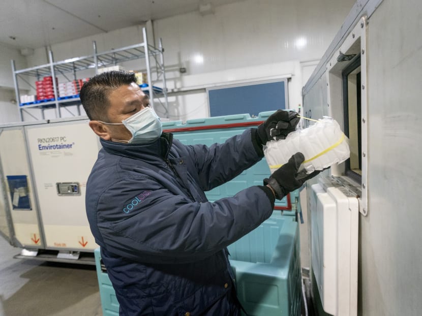 An employee from airport ground handler Sats' Coolport packing dry ice slabs into temperature-controlled containers as secondary packaging.