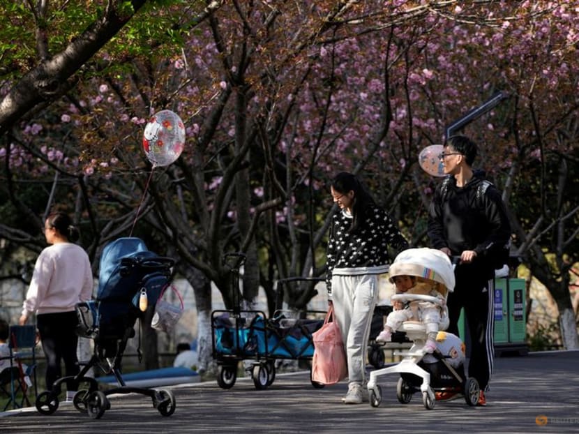 A parent pushes a stroller with a baby in a park in Shanghai, China on April 2, 2023. 