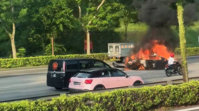 黑色轿车疑失控打滑后起火燃烧 一人送院
