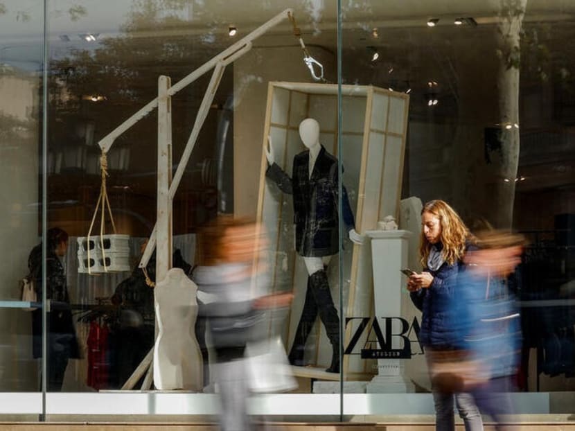 People walk past a Zara shop window at Passeig de Gracia in Barcelona, Spain, December 11, 2023. 