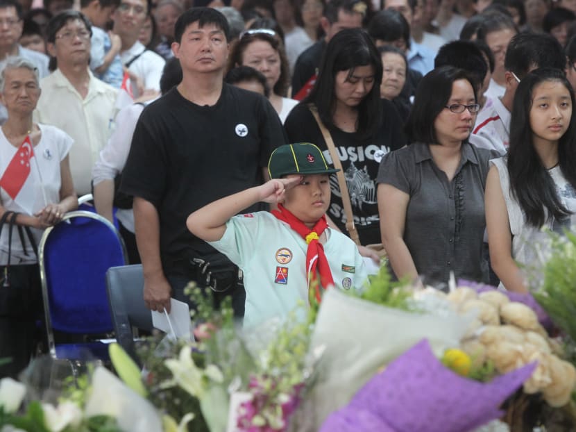 A boy salutes during the observation of one-minute silence at the end of the State Funeral of the late Lee Kuan Yew, which was telecast 'live' at Ang Mo Kio Central Stage@Ang Mo Kio Town Centre on March 29, 2015. Photo: Ooi Boon Keong