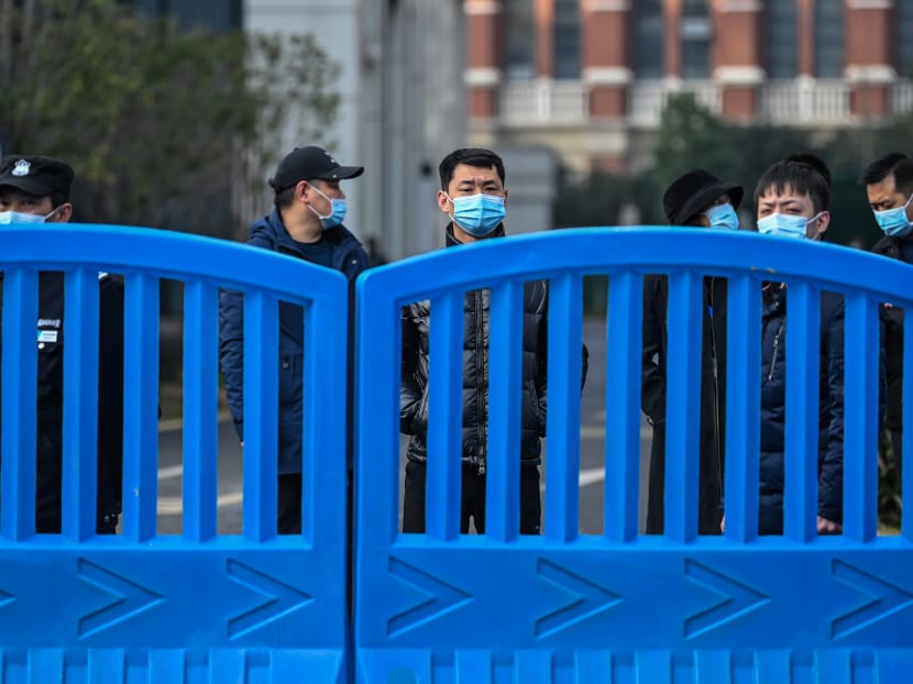 Security personnel look on from the compounds of the Wuhan centre for disease control and prevention during a visit by the World Health Organization team investigating the origins of Covid-19 in Wuhan, China's central Hubei province on Feb 1, 2021.