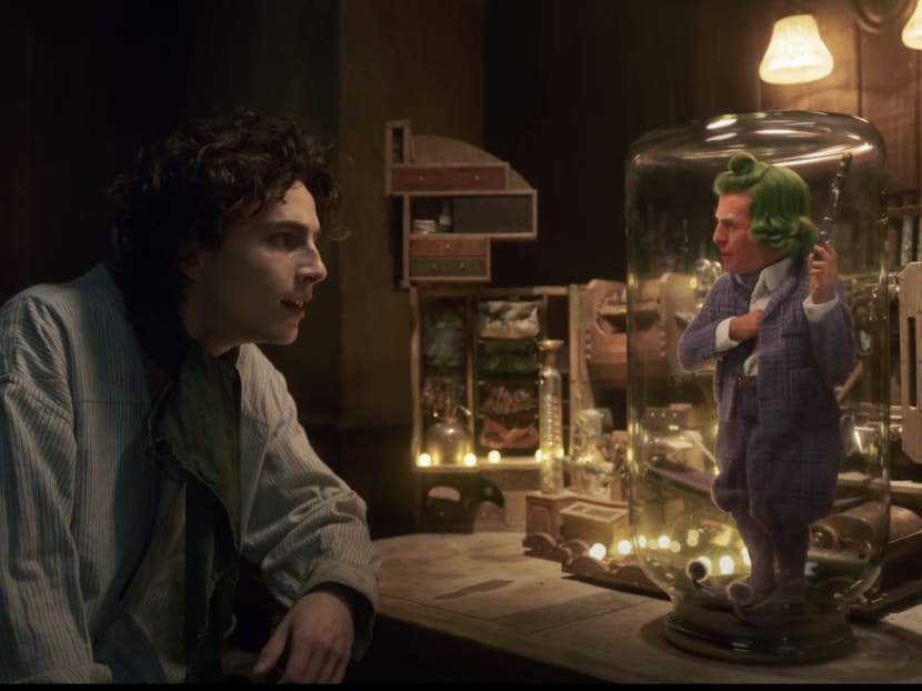 Trailer Watch: Timothée Chalamet & Hugh Grant (As An Oompa-Loompa!) Team Up To Make Chocolate In Wonka 