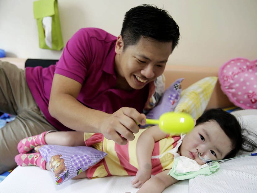 Mr Xie Dingshan with his daughter Xie Xin Lin who has Spinal Muscular Atrophy-Type 1. Photo: Wee Teck Hian/TODAY