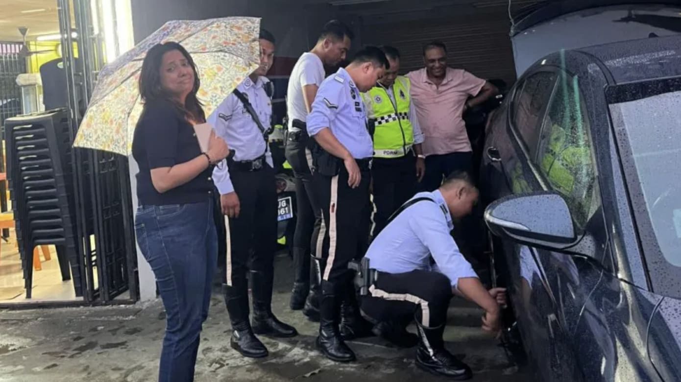 狮城女游客自驾途中爆胎 马国交警伸援手助换轮胎