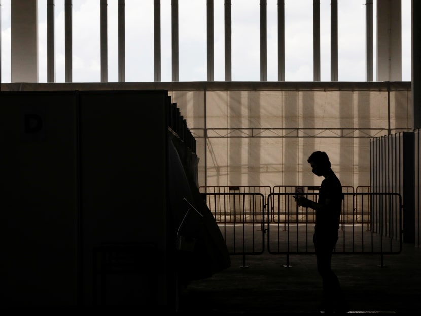 A man wearing a protective face mask is seen at a new medical facility set up to test migrant workers from dormitories for Covid-19.