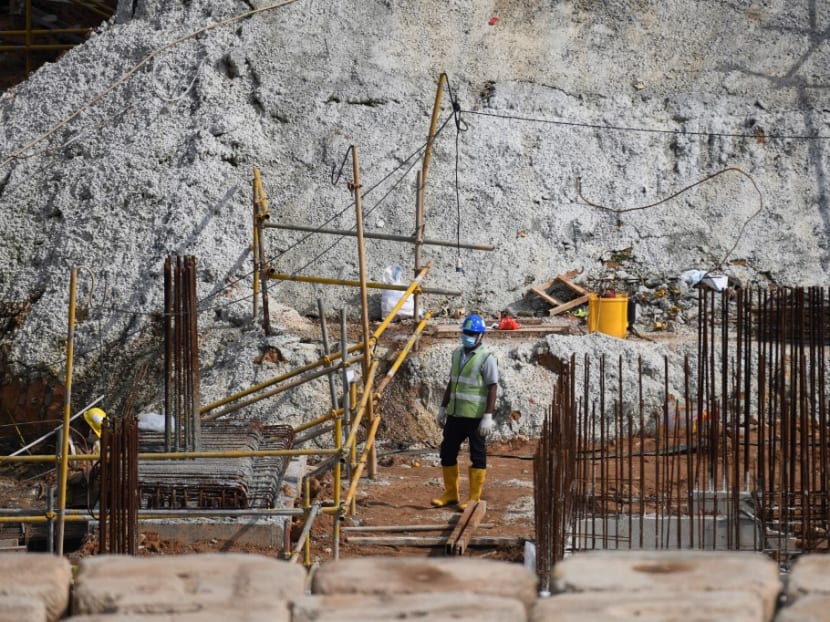 A migrant worker looks on in a construction site in Singapore on August 20, 2020.