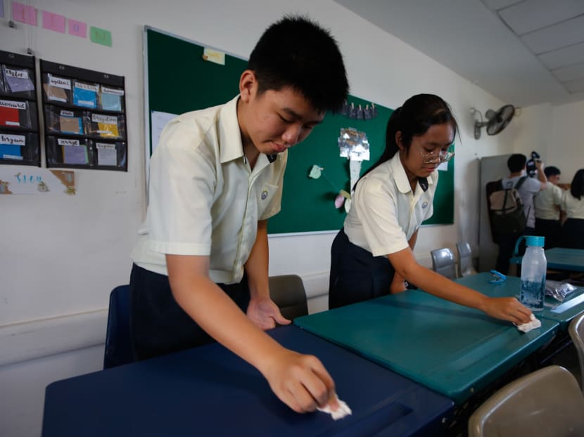 Kent Ridge Secondary School students wipe their desks on March 13, 2020 as part of a Clean Up Wipe Down Campaign introduced on Total Defence Day this year.