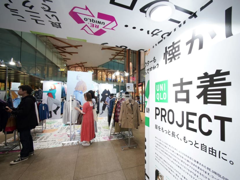 This picture taken on Oct 17, 2023 shows customers browsing through items sold as part of the Uniqlo Pre-owned Clothes Project at the brand's Harajuku store in Tokyo. 