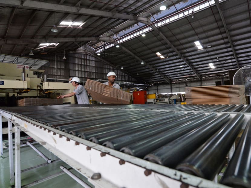 Factory workers moving packaging boxes at the TCG Rengo (S) Ltd factory. TODAY file photo