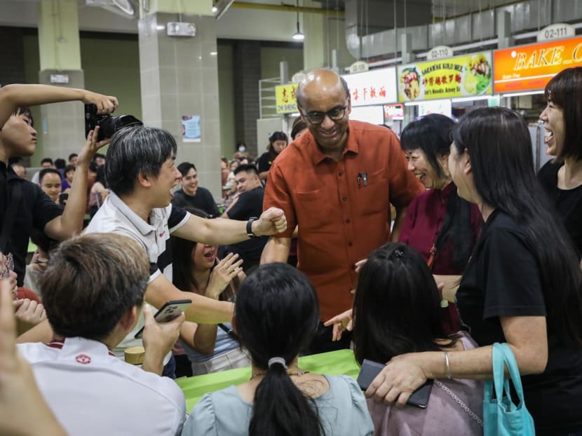 Mr Tharman and his wife Jane Ittogi (both in red) on a walkabout at Amoy Street Food Centre on Aug 25, 2023. Mr Tharman and his wife Jane Ittogi (both in red) on a walkabout at Amoy Street Food Centre on Aug 25, 2023.