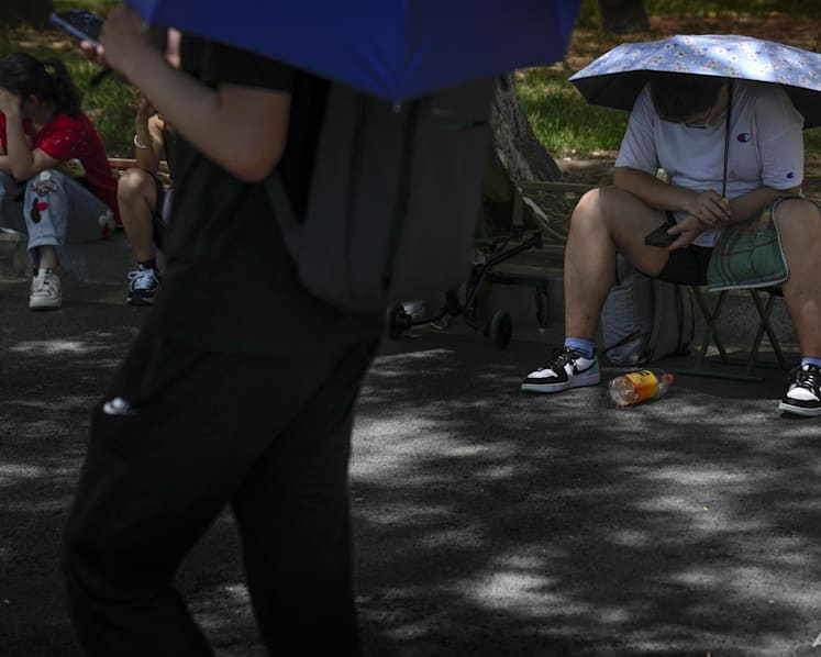 Rain and shine: Northern China swelters in heatwave as torrential downpours soak the south 