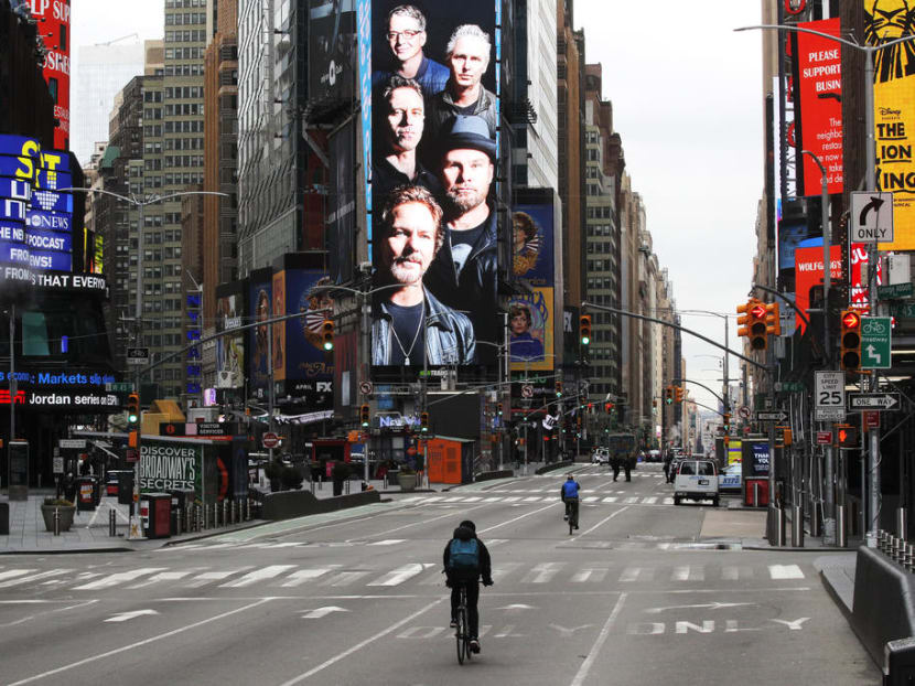Cyclists ride through a nearly empty Times Square during the coronavirus disease (Covid-19) in New York.