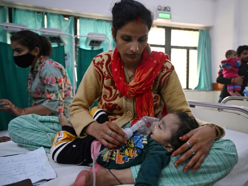 In this picture taken on Nov 7, 2023, a mother assists her child to breathe with the help of a nebuliser at the emergency ward of the government-run Chacha Nehru Bal Chikitsalaya children hospital in New Delhi.