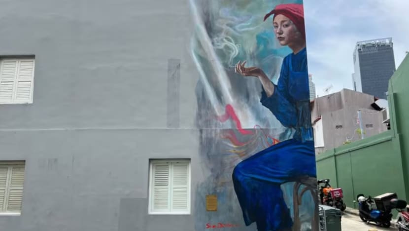 Plak dengan mesej antimerokok dipasang pada mural wanita samsui di Chinatown