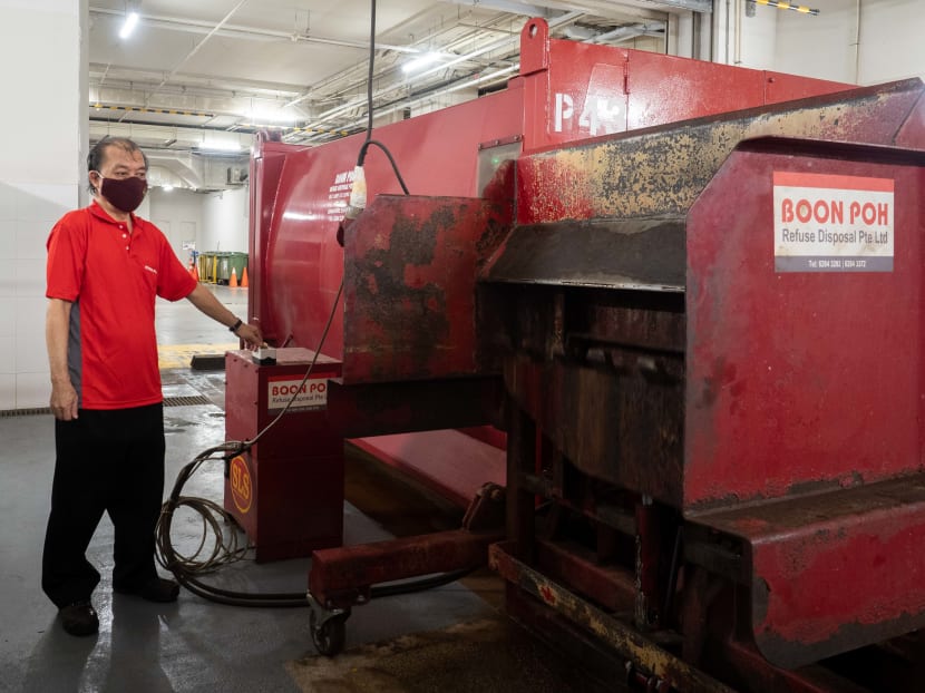 Waste sorter Yeo Hock Lye operating a trash compactor on Jan 24, 2022.