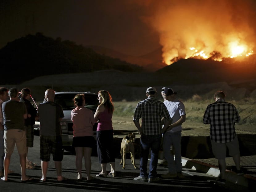Residents watch a fast-moving wildfire approach in San Marcos, California May 14, 2014. Photo: Reuters