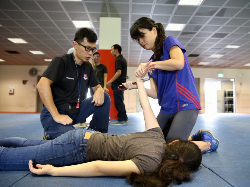TODAY journalist Kelly Ng seen learning how to handcuff during the basic police defence tactics training.