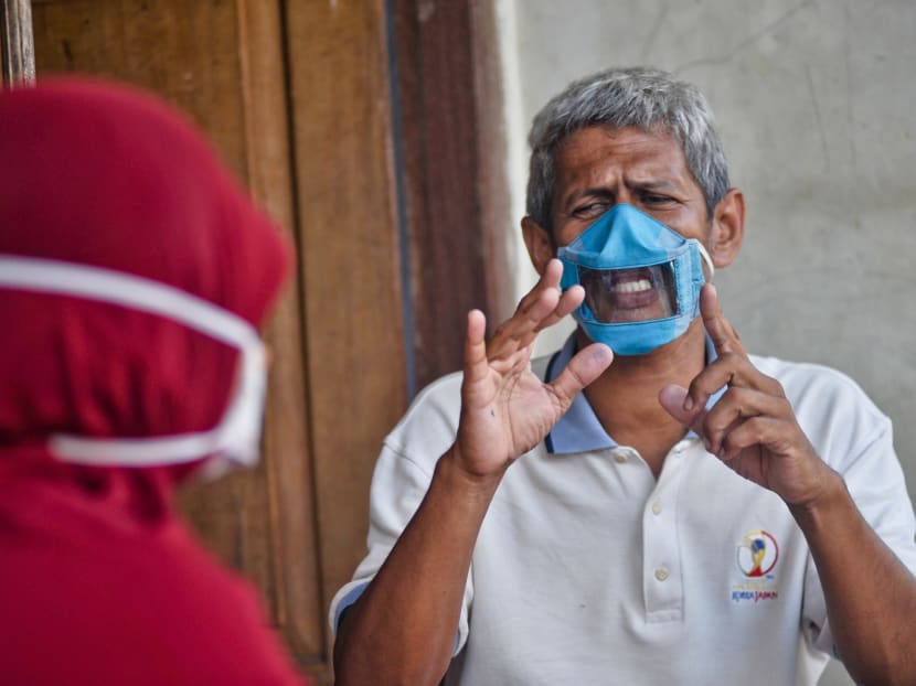 Indonesians Dwi Rahayu and her husband Elfiandi who are deaf and mute communicate while wearing face masks with a transparent cover in Yogyakarta on April 22, 2020. Indonesians Dwi Rahayu and her husband Elfiandi who are deaf and mute communicate while wearing face masks with a transparent cover in Yogyakarta on April 22, 2020.