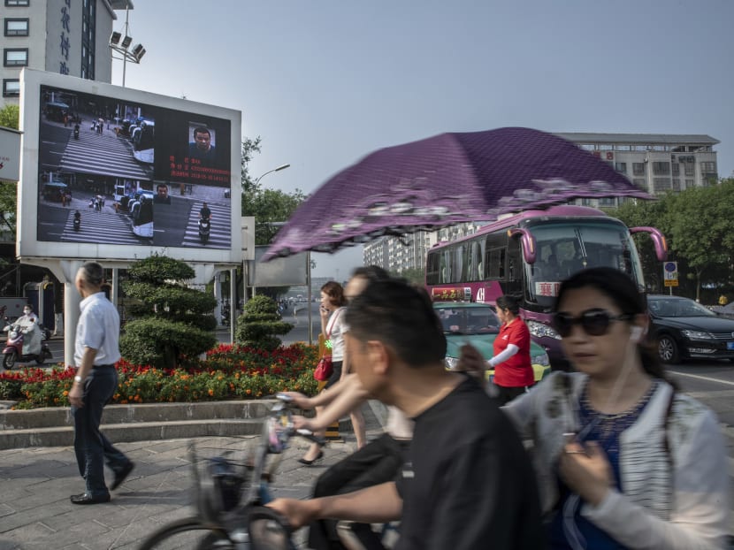 A crossroad equipped with monitoring cameras linked to facial recognition technology displays jaywalkers' faces and names on a screen, in Xiangyang, China. China’s headlong push into the world of artificial intelligence and other frontier technologies highlights the relationship between the Chinese Communist party and the country’s ambitious and enormous tech companies.