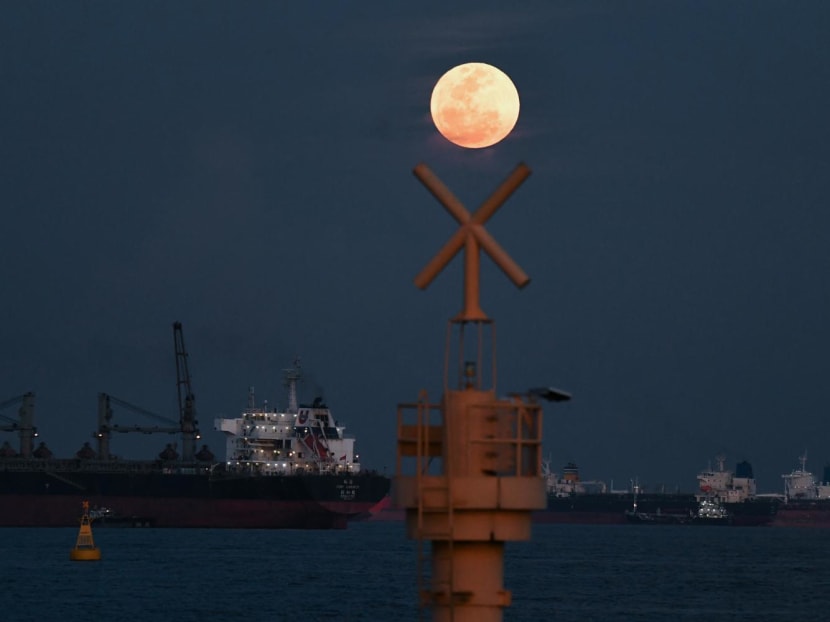 The full moon rises as the June 2022 "Strawberry Supermoon" in Singapore on June 14, 2022.