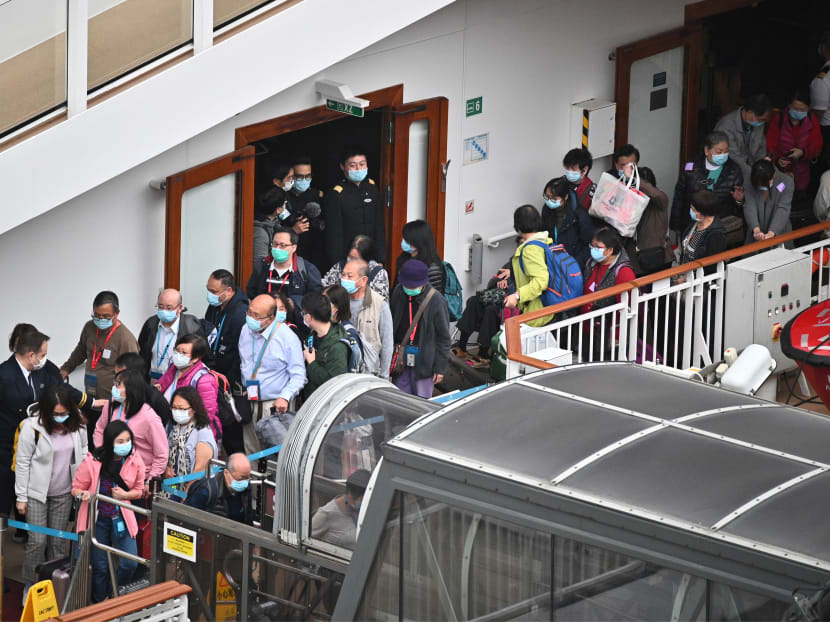 Passengers queue up to disembark from the World Dream cruise ship at the Kai Tak cruise terminal in Hong Kong on Feb 9, 2020.
