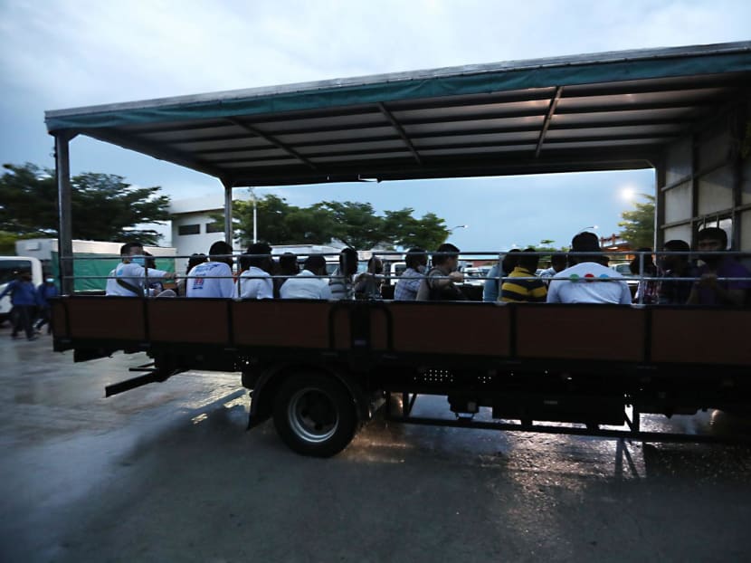 A file photograph of workers being ferried on the back of a lorry.