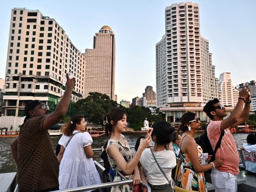 Tourists look at the view from the top deck of a tourist commuter boat on the Chao Praya River in Bangkok on Dec 27, 2023. Tourists look at the view from the top deck of a tourist commuter boat on the Chao Praya River in Bangkok on Dec 27, 2023.