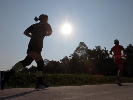 Two people running under the sun in Woodlands, Singapore in April 2024. 