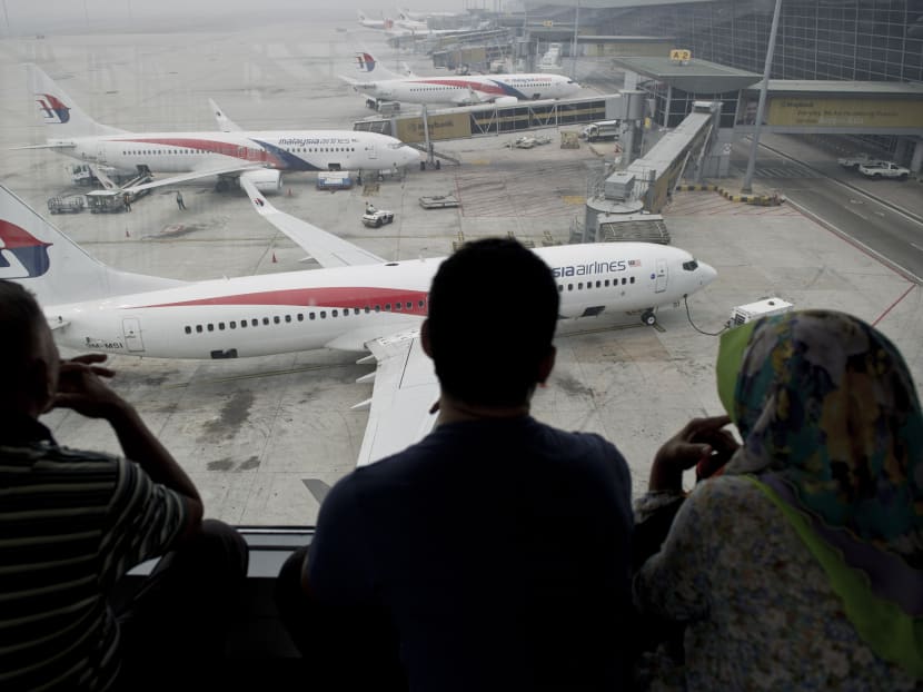 Passengers watch Malaysia Airlines planes on the tarmac at Kuala Lumpur International Airport (KLIA). Customer complaints of dirty toilets, unfriendly staff and long queues have caused KLIA to steadily lose its position as one of the top 10 airports in the world. Photo: AFP