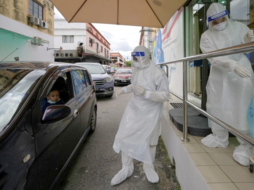 Medical personnel wearing protective suits conduct Covid-19 testing at a drive-through centre outside the Ajwa Private Clinic in Shah Alam on the outskirts of Kuala Lumpur, Malaysia on Jan 12, 2021. Medical personnel wearing protective suits conduct Covid-19 testing at a drive-through centre outside the Ajwa Private Clinic in Shah Alam on the outskirts of Kuala Lumpur, Malaysia on Jan 12, 2021.