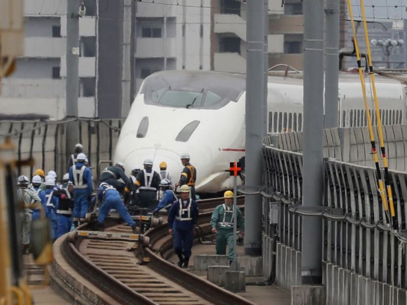 Railway workers labour to fix a Kyushu shinkansen (bullet train) after it derailed from its tracks during the recent earthquakes in Kumamoto on April 18, 2016. Photo: AFP