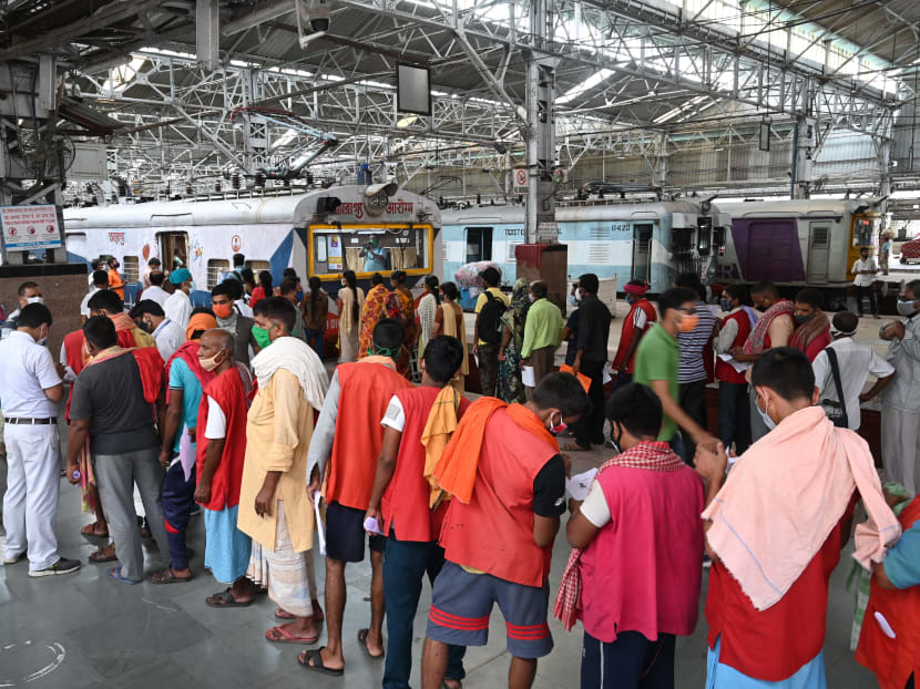 Railway porters wait in a queue to get a dose of the Covishield Covid-19 vaccine inside railway compartments modified as a temporary vaccination centre at Sealdah railway station in Kolkata, India on July 22, 2021.