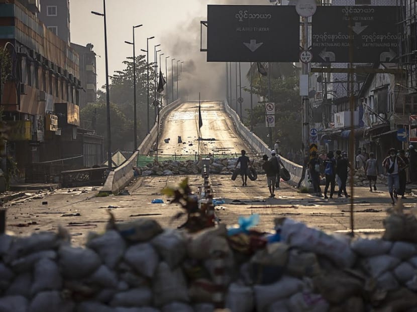 Protesters carry tires to construct makeshift barricades during demonstrations against the military coup in Yangon on Monday, March 15, 2021.