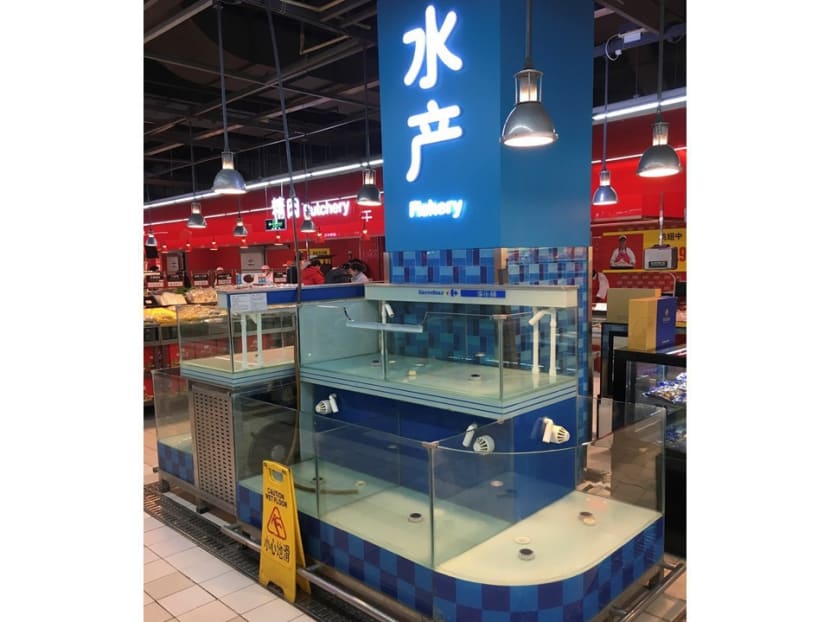 Tanks that normally hold freshwater fish sit empty in a supermarket. Photo: The New York Times