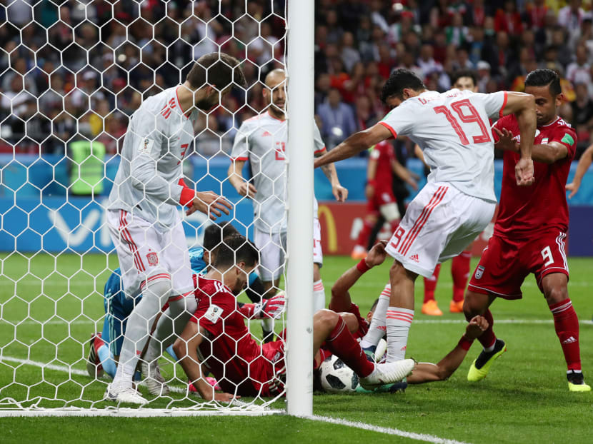 Spain's Diego Costa and Gerard Pique in action with Iran's Saeid Ezatolahi on the goal line, June 20, 2018 Spain's Diego Costa and Gerard Pique in action with Iran's Saeid Ezatolahi on the goal line, June 20, 2018