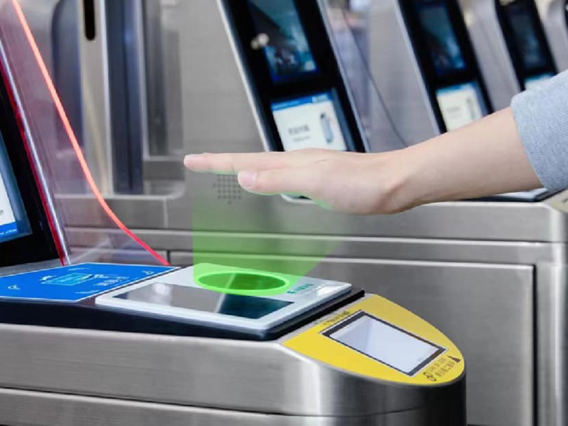 A hand hovering over a scanner at a metro station turnstile in Beijing. 
