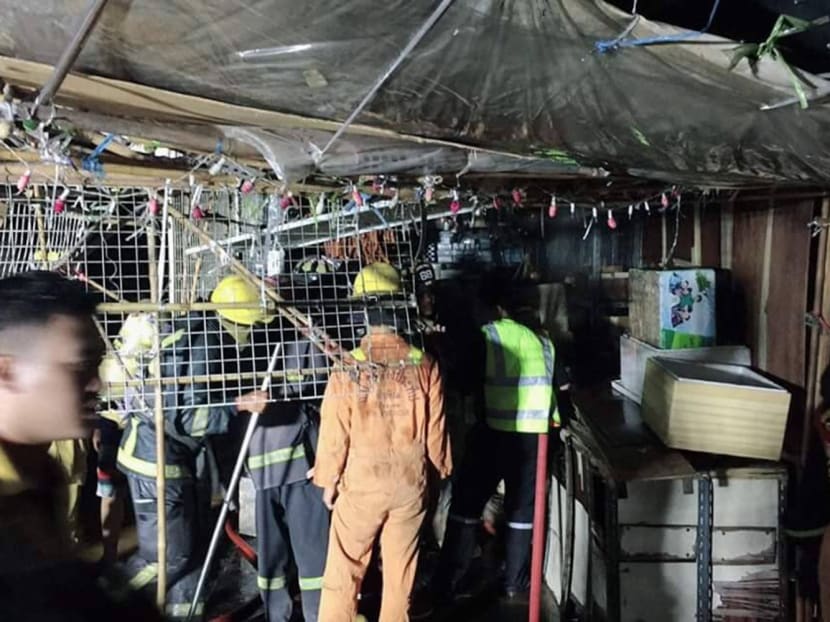 Firefighters and volunteers inspect the damage after they put out a fire at Chatuchak market on Sunday night.