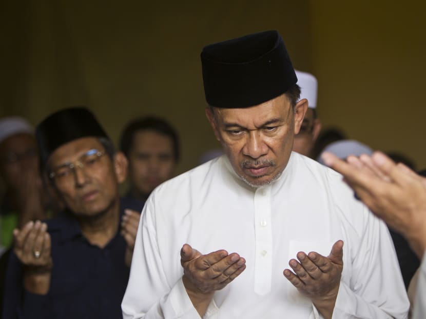 Malaysia's jailed opposition leader, Anwar Ibrahim prays during a special prayer for his late father, Ibrahim Abdul Rahman, 96, in their house outside Kuala Lumpur, Malaysia, on Sunday, April 5, 2015. Photo: AP