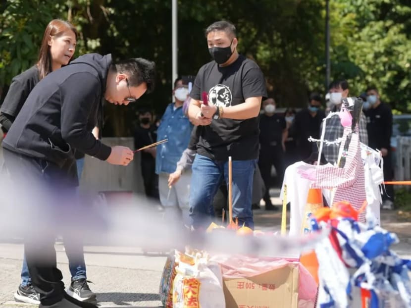 Choi’s current husband (centre front) pays his respects outside the Tai Po crime scene.